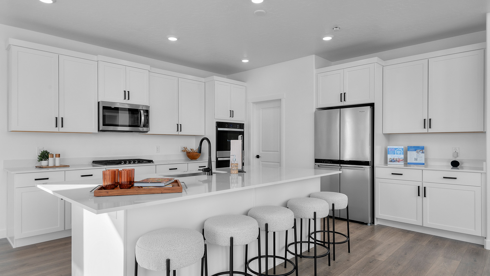 Spacious kitchen with quartz countertops, pendant lighting and stainless steel appliances.