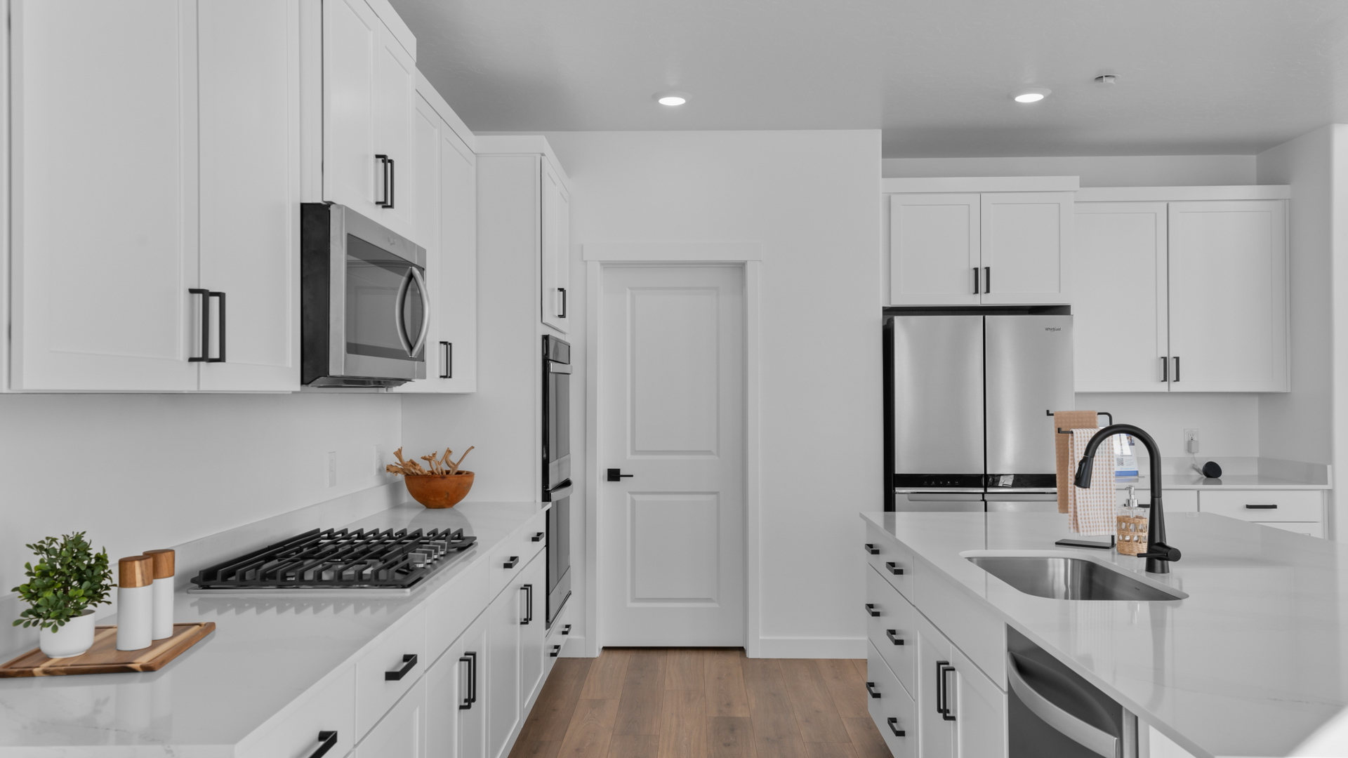 Spacious kitchen with quartz countertops, pendant lighting and stainless steel appliances.