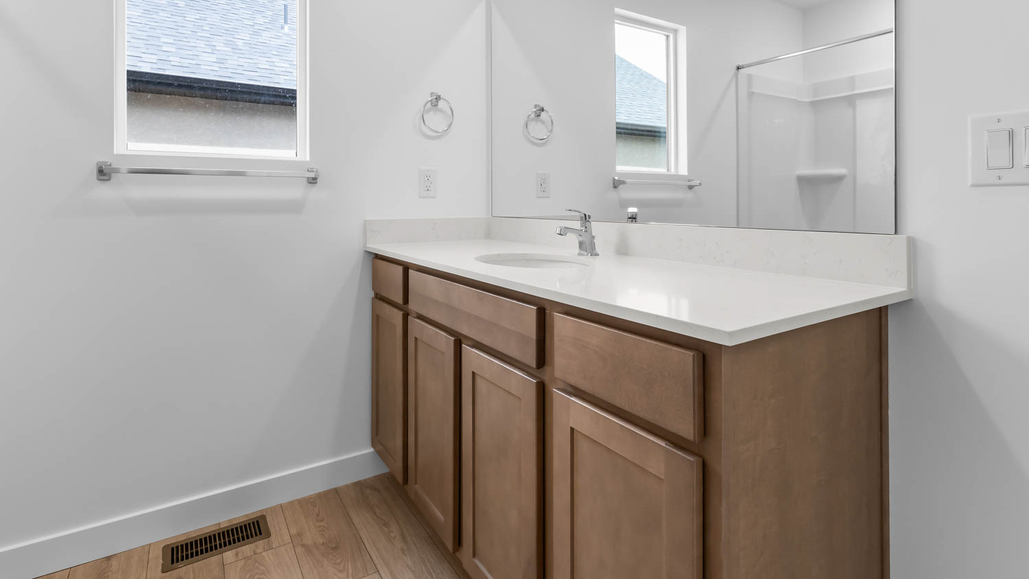 Primary bathroom with vanity and shower surround and window.