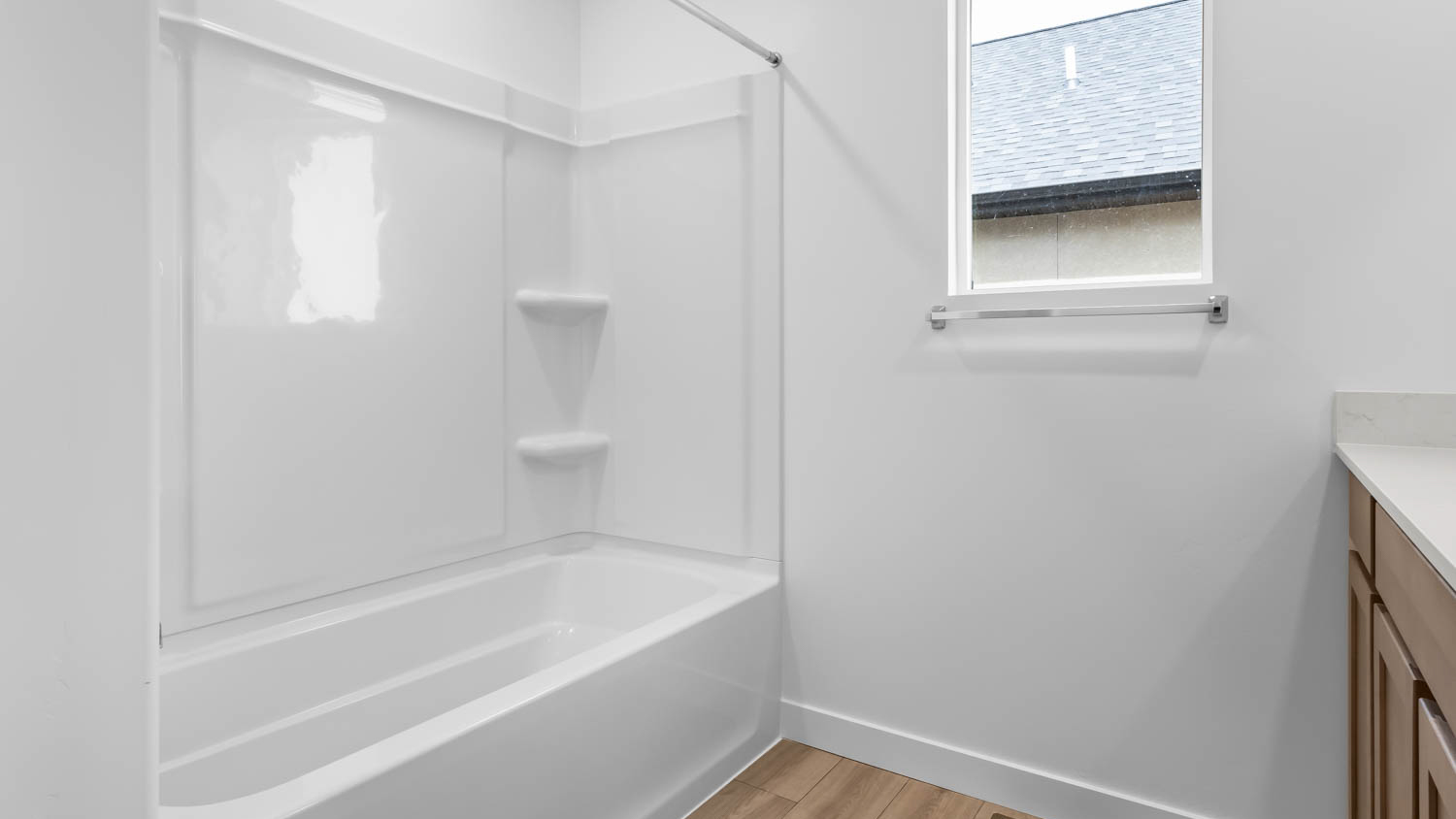Primary bathroom with vanity and shower surround and window.