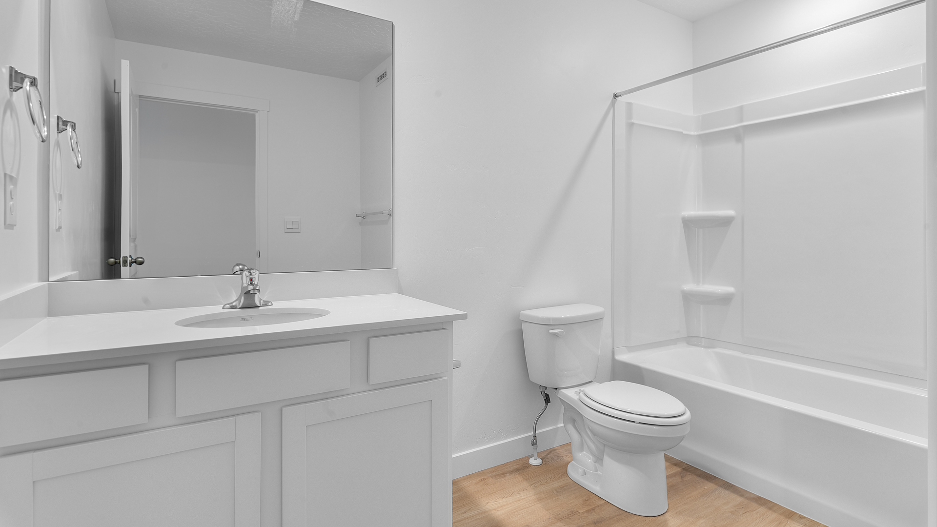 Primary bathroom with vanity and shower surround and window.