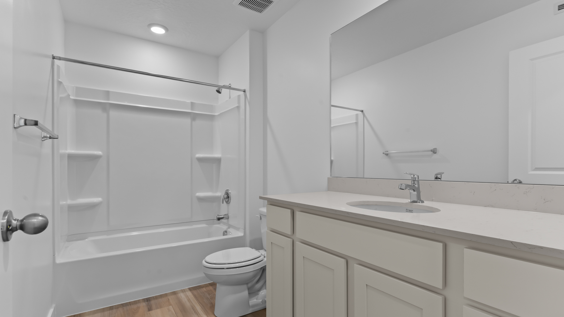 Bathroom with large vanity and shower surround.