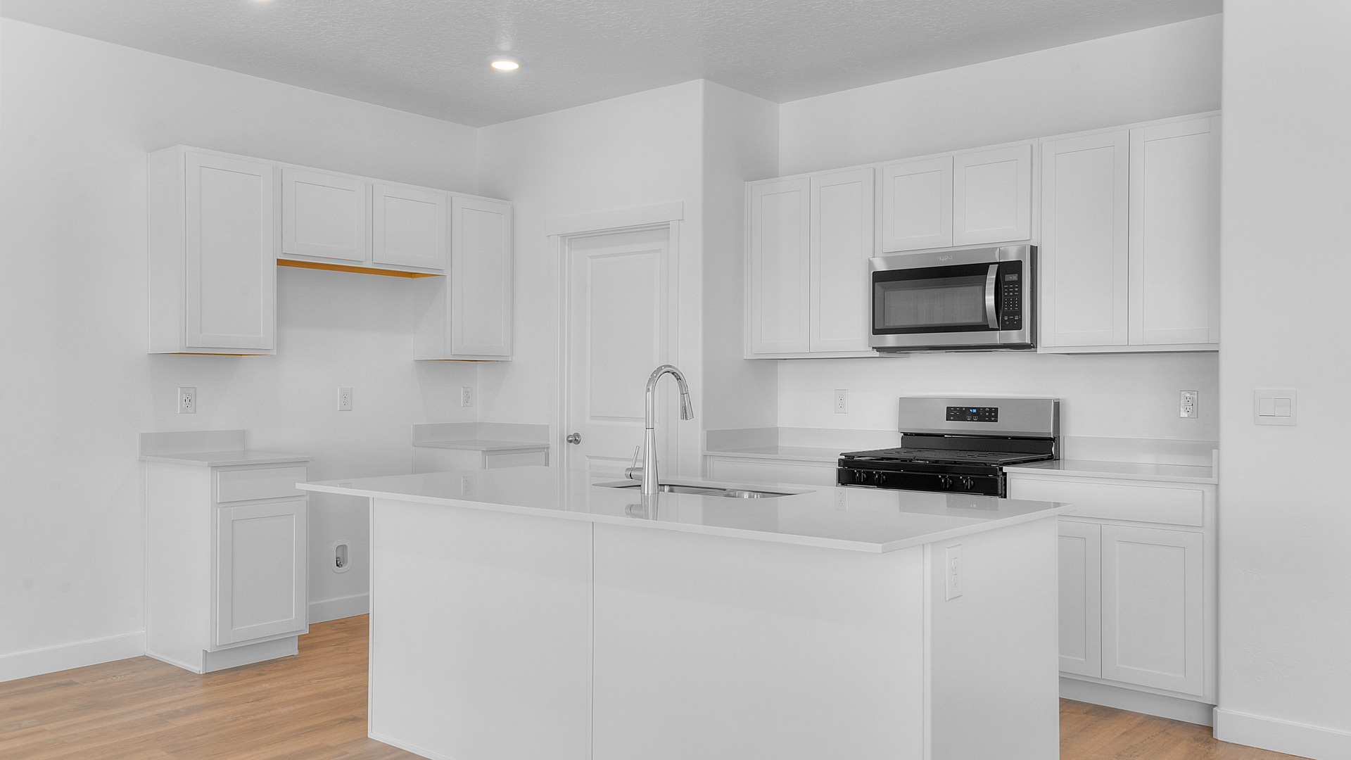 Kitchen space with ktichen island and stainless steel appliances.