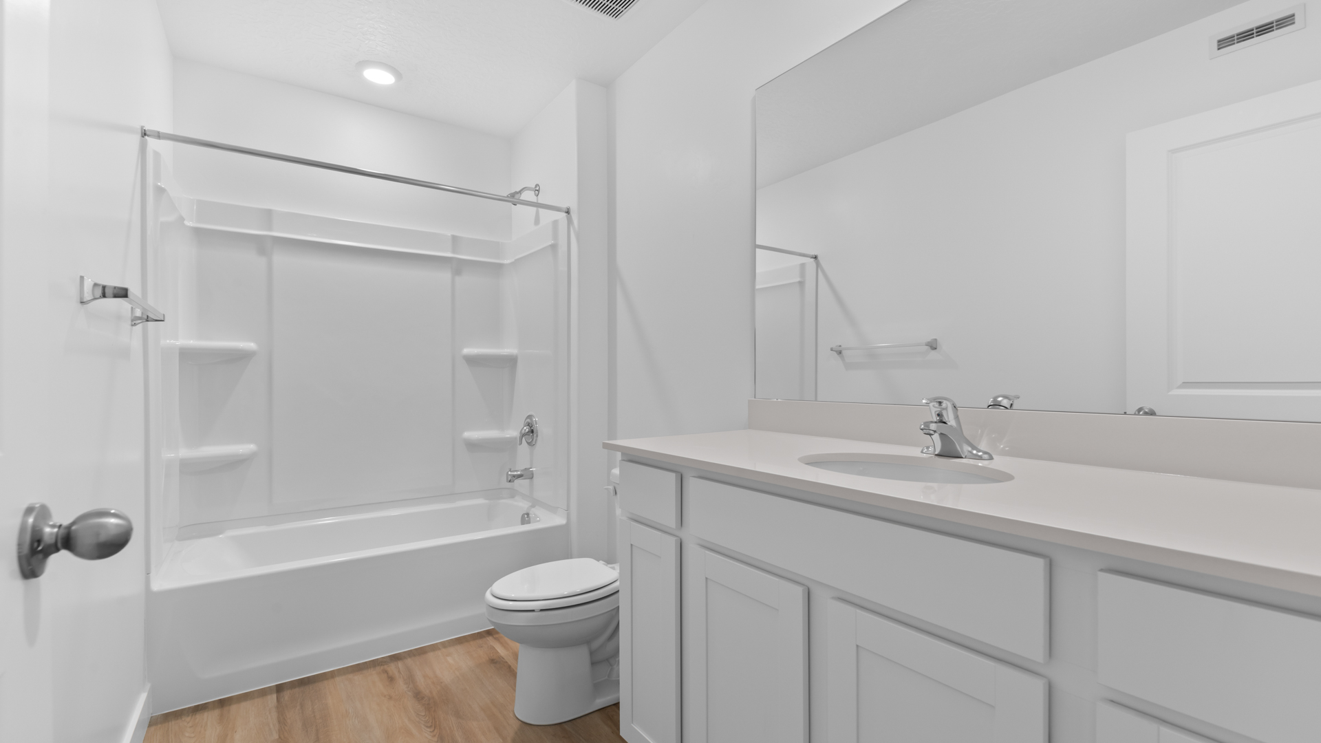 Bathroom with large vanity and shower surround.