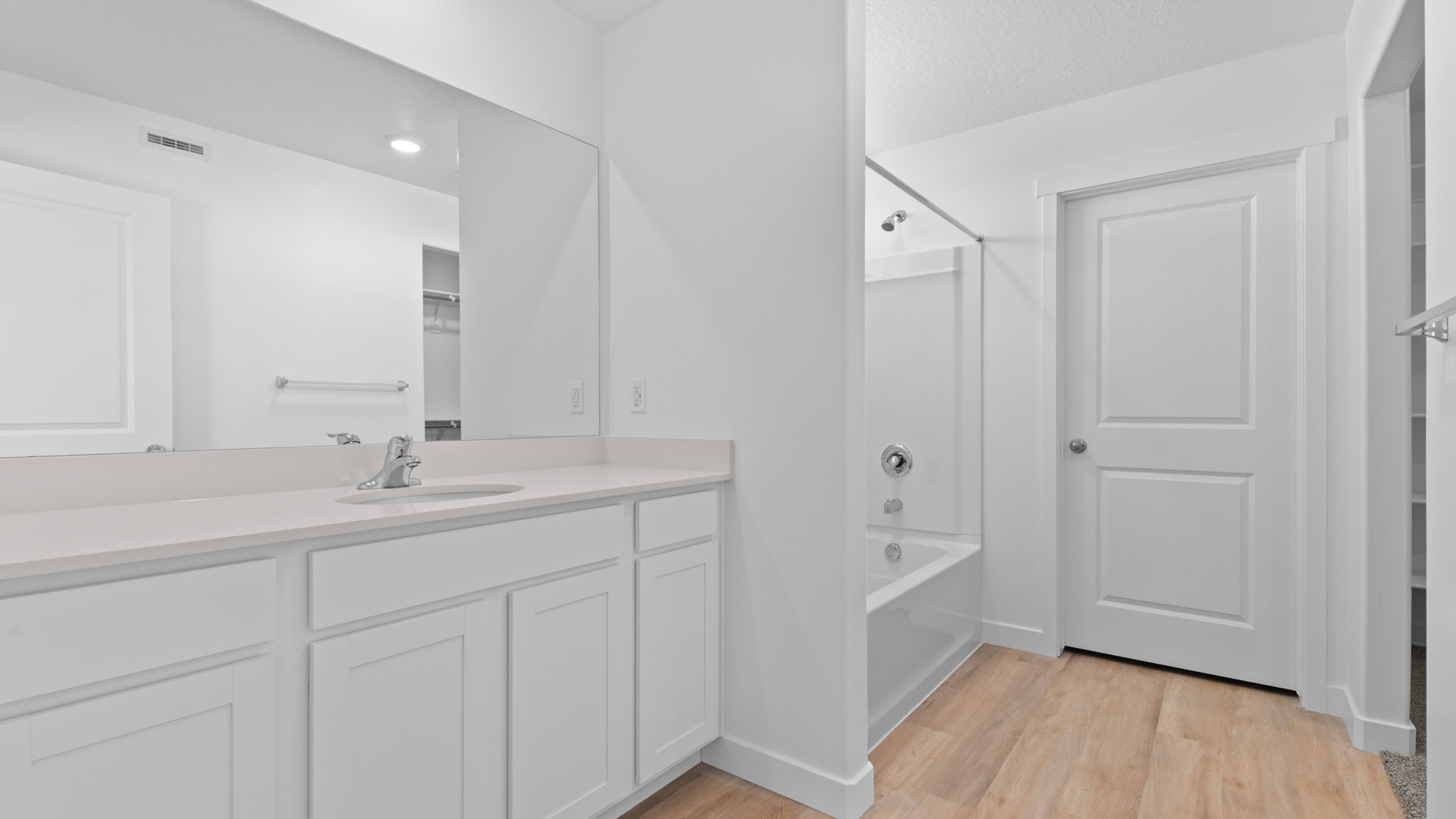Primary bathroom with large vanity and shower surround.