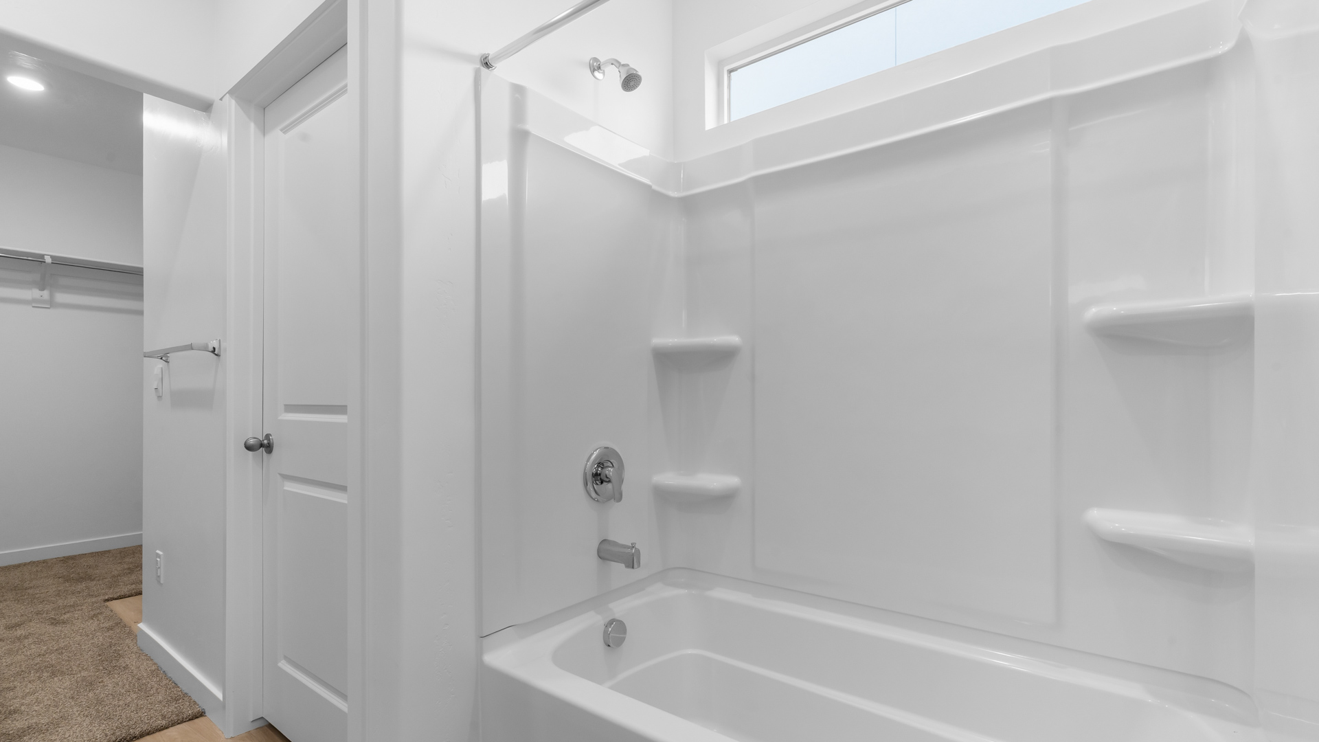 Shower and tub with window in primary bathroom.