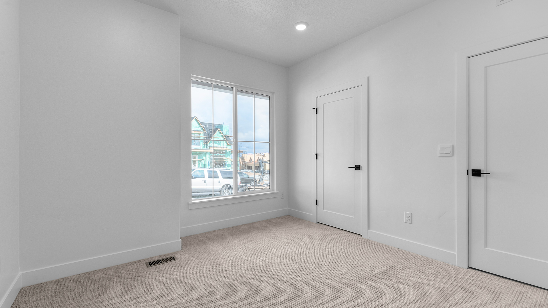 Front bedroom with window and walk-in closet.