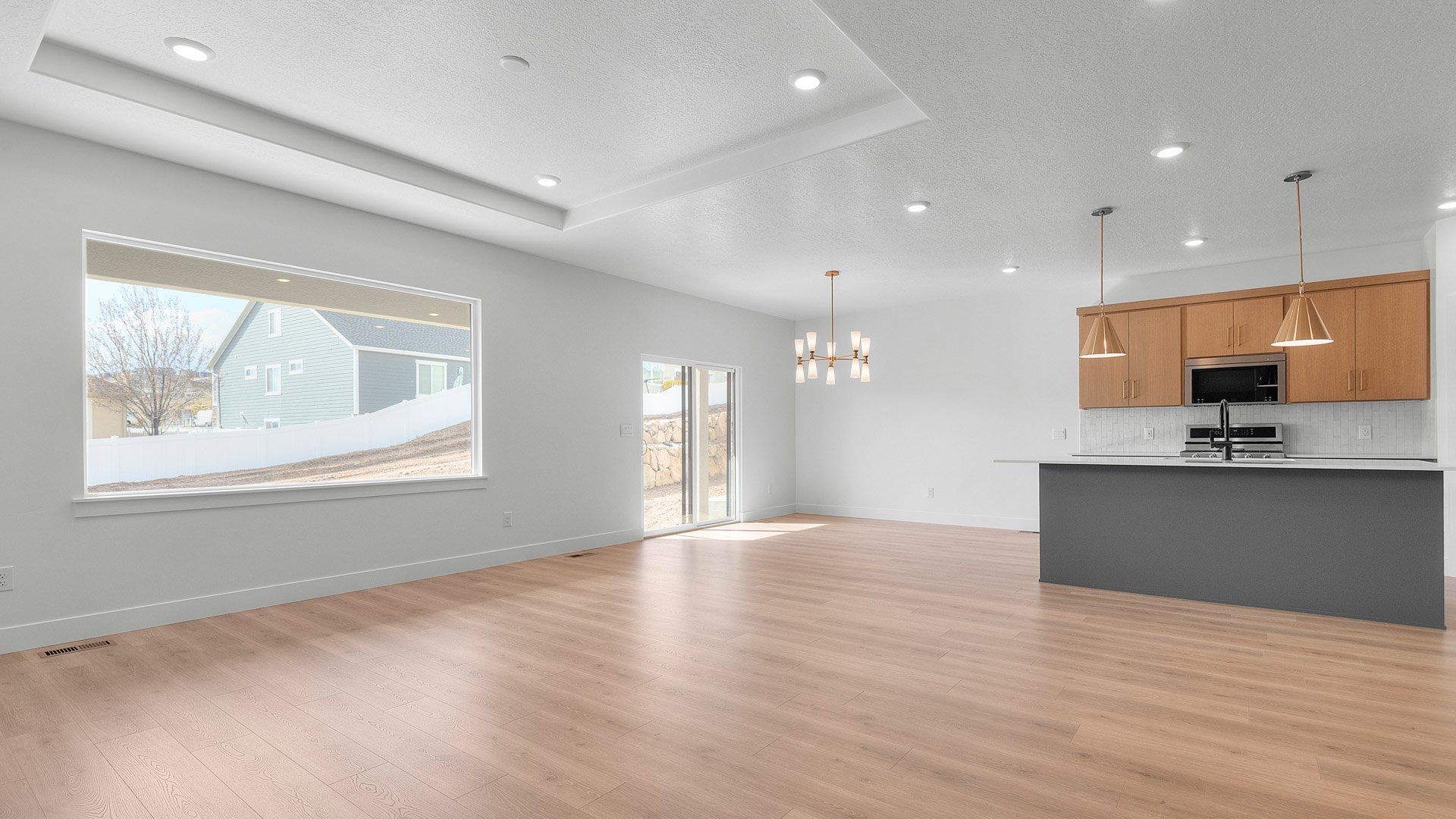 Main living space with tray ceiling and kitchen and dining.