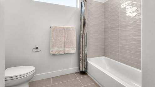 Water closet space with window, shelving, and shower.
