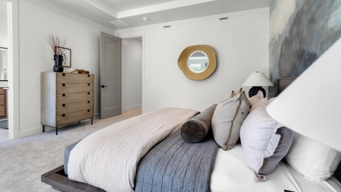 Primary bedroom with large window and tray ceilings.