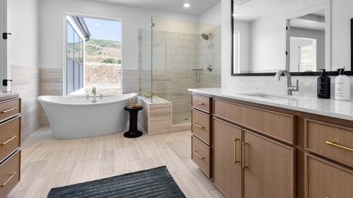 Primary bathroom with two vanities, glass shower, and tub.