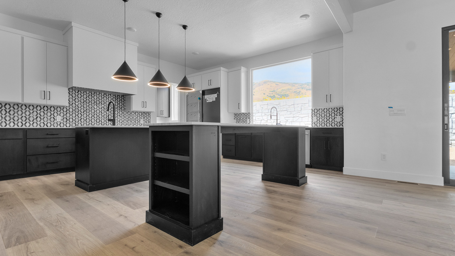 Kitchen with two kitchen islands, stainless steel appliances, and window.