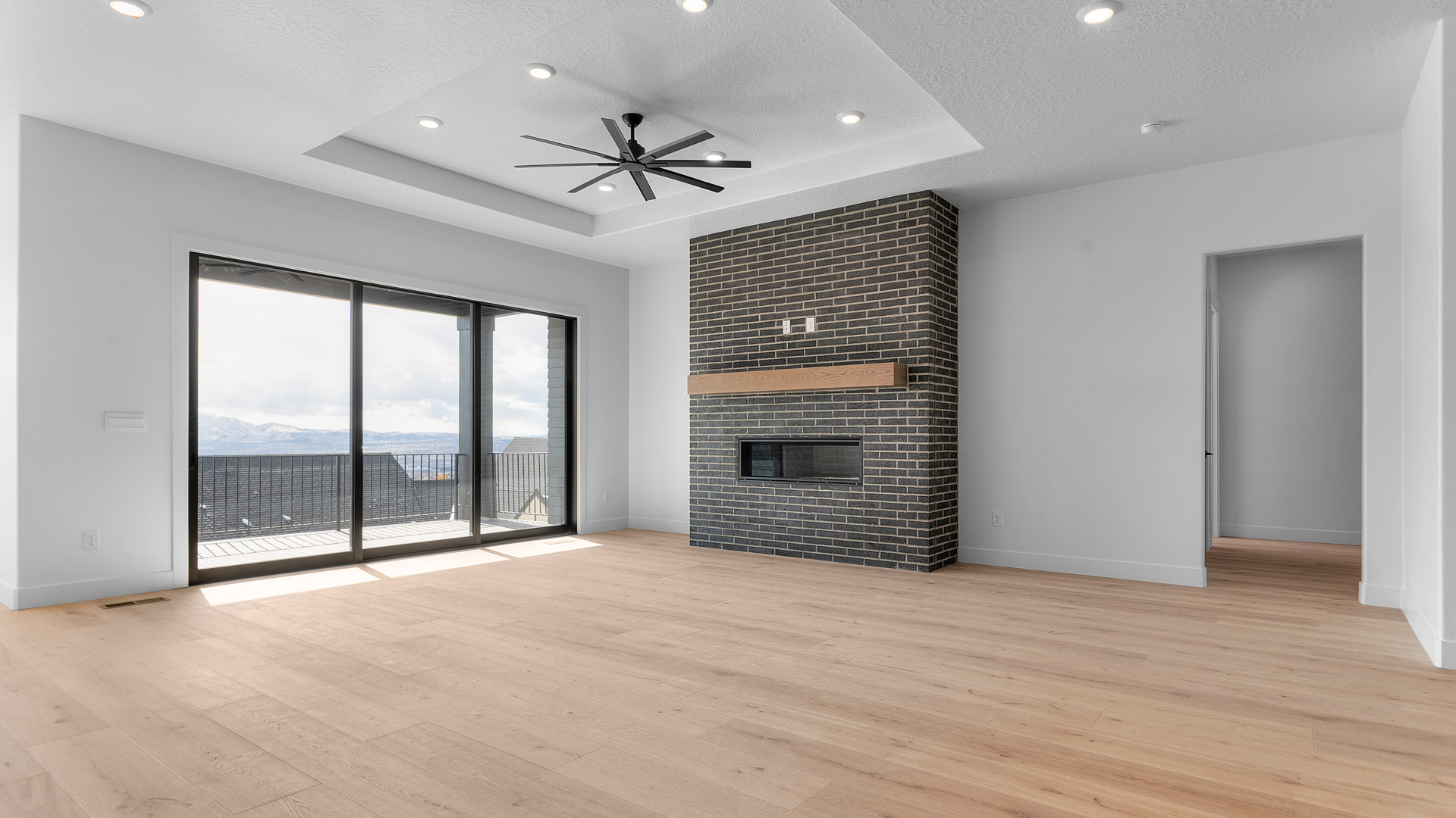Family room with fireplace, tray ceiling, and large patio doors.