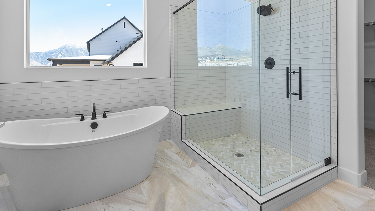 Primary bathroom with tub and glass shower.