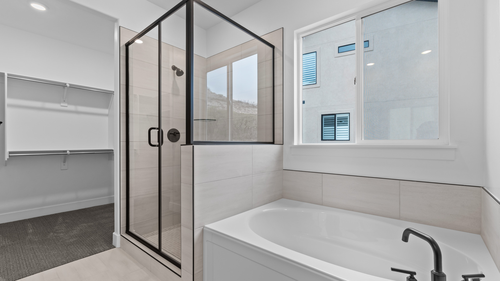 Primary bathroom with shower and bath with window.