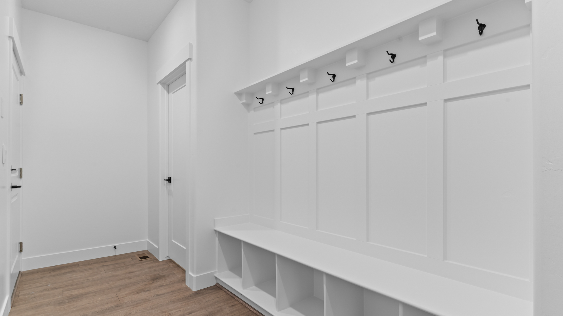 Mudroom with storage bench off of garage.