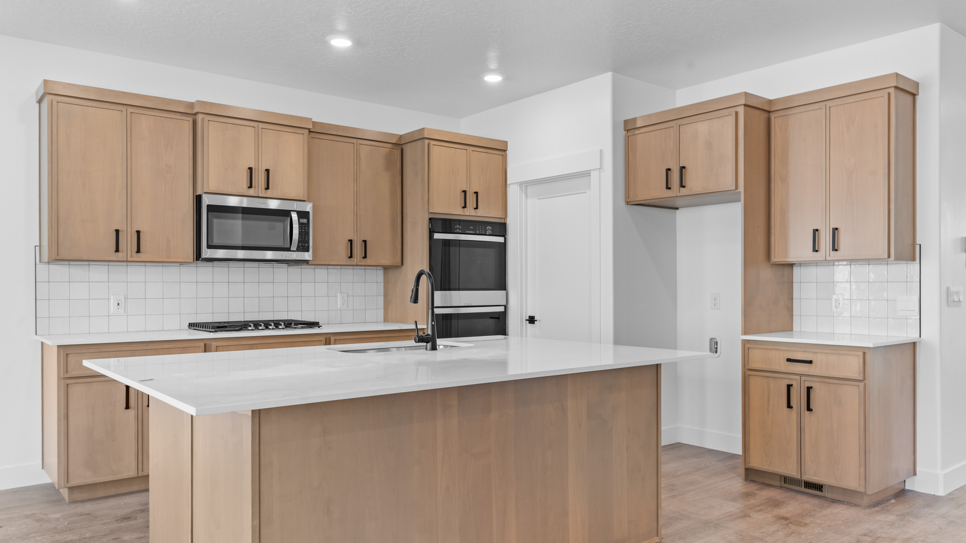 Kitchen with kitchen island, quartz countertops, and stainless steel appliances.