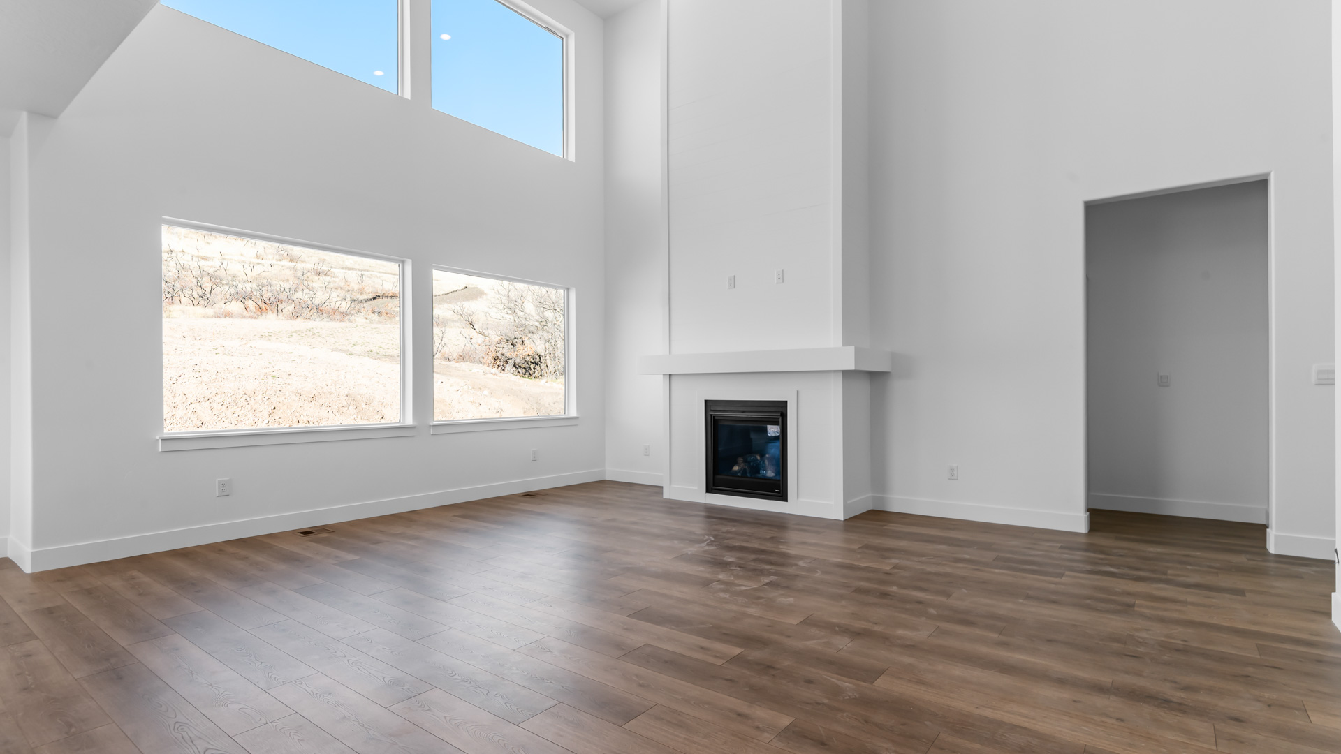 Family room with fireplace and large windows 2 story.