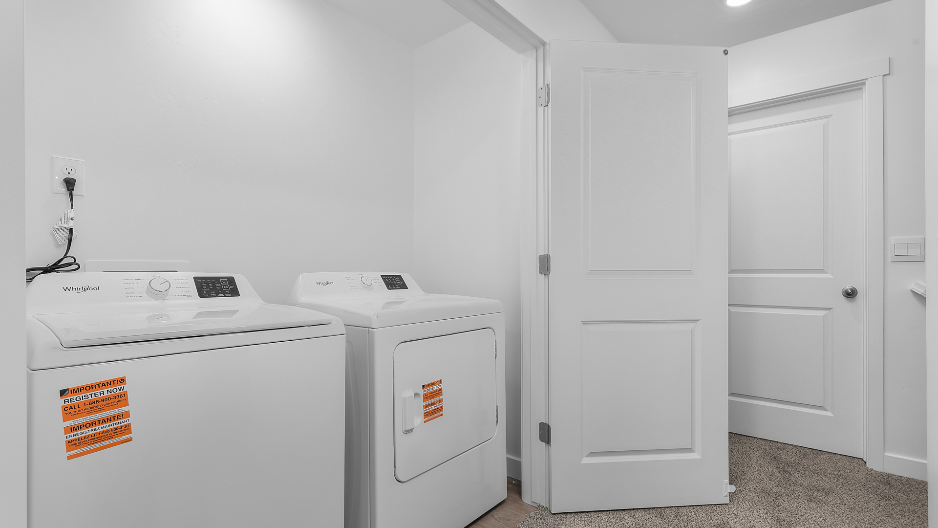 Laundry area behind double doors in hallway.