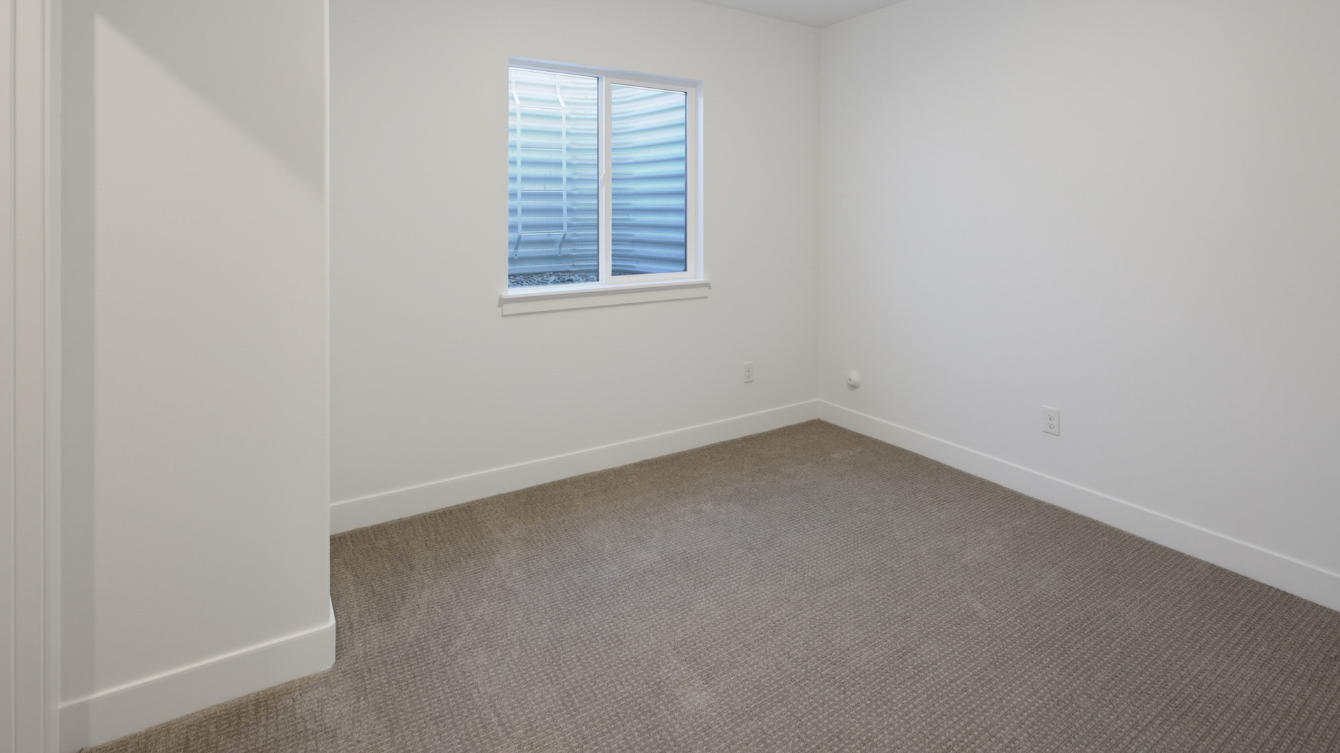 Basement bedroom with large window.