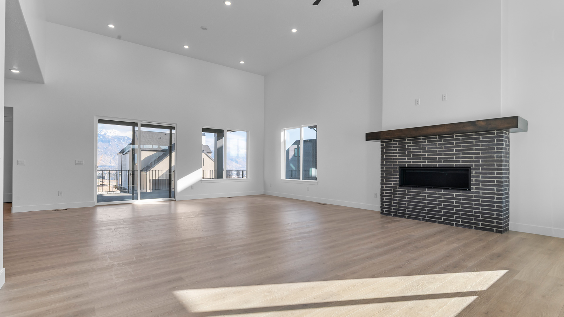 Family room with tall ceiling and fireplace and dining space.