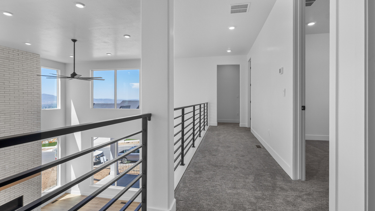Upstairs hallway with railing open to below into living room.