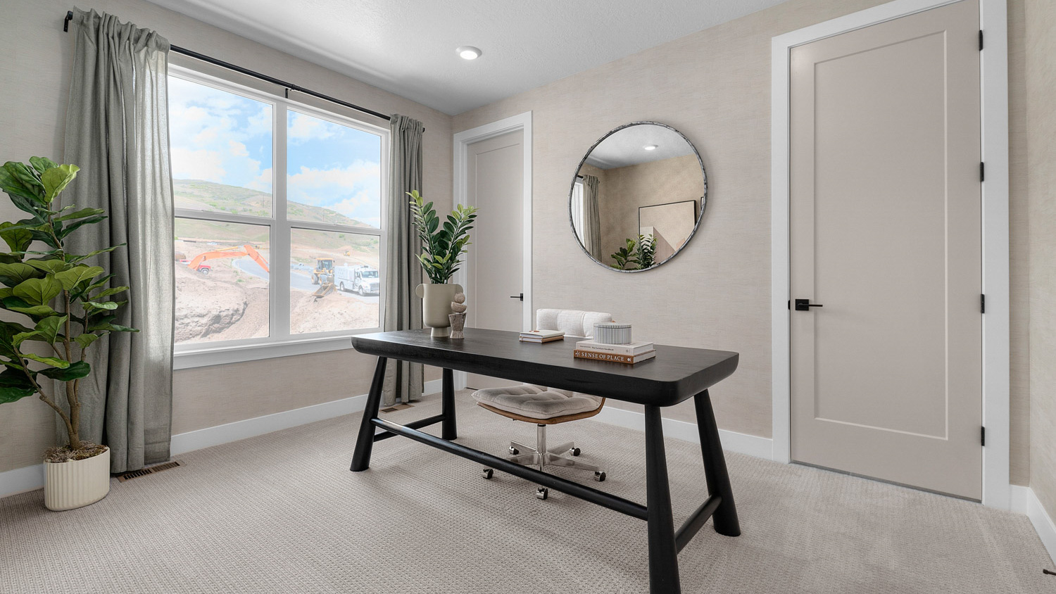 Room used as office with large window.