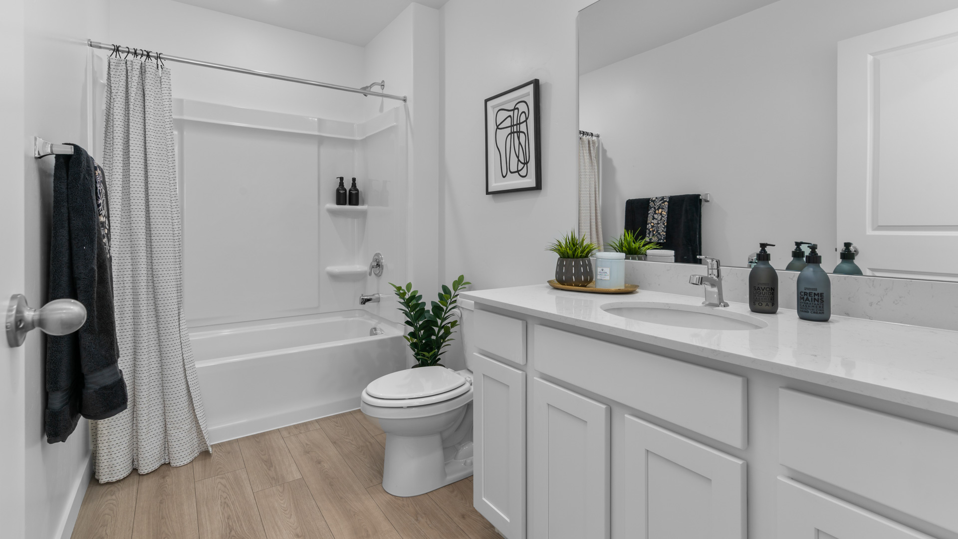 Bathroom with large vanity and shower surround.
