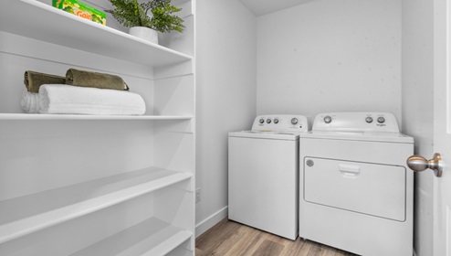Spacious laundry room with shelving.