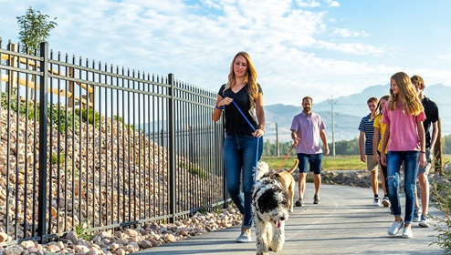Family with dog strolling by in the Eagle Point Townhomes community.