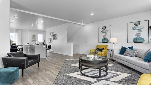 Open concept main floor living space with a spacious living room, dining area and kitchen complete with large island and sink with stainless steel appliances.