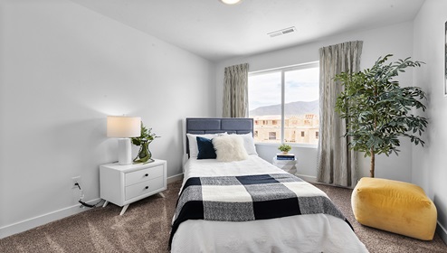 Equally as stylish is another secondary bedroom with a large window in the Eagle Point Townhome community in Eagle Mountain Utah.