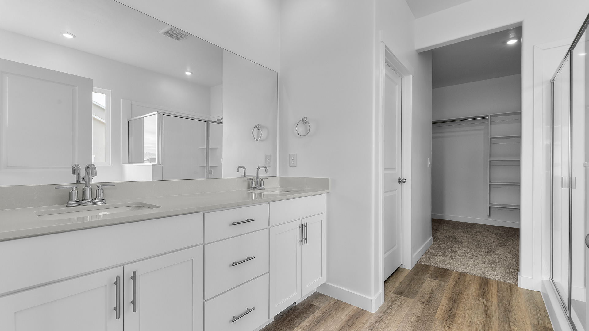 Primary bathroom with double sink vanity and white cabinets and countertops.