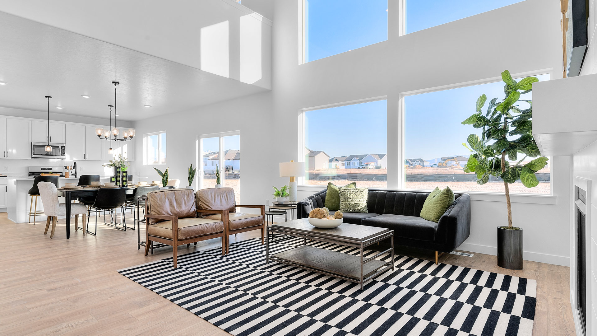 Spacious living room with large two story windows and fireplace.