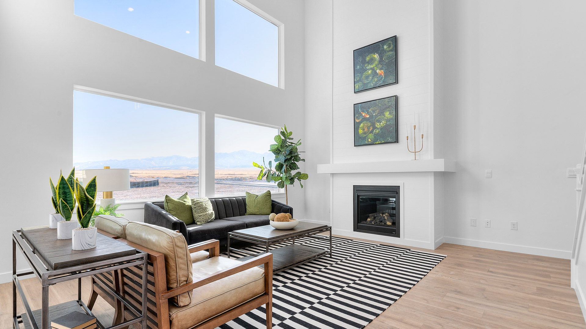 Spacious living room with large two story windows and fireplace.