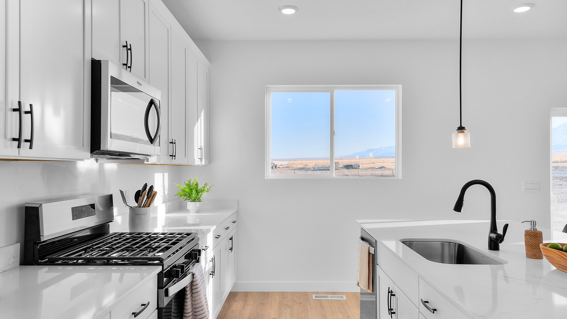 Kitchen area with white cabinets and countertops with kitchen island.