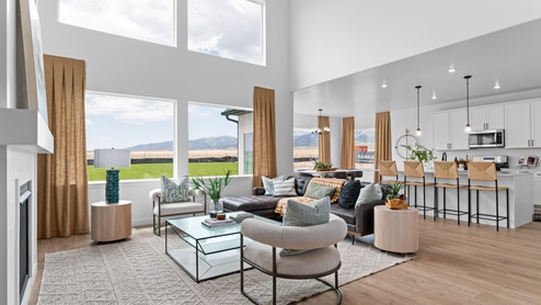 Main living space with two story windows and fireplace.