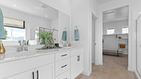 Primary bathroom with double sink vanity and white cabinets and countertops.
