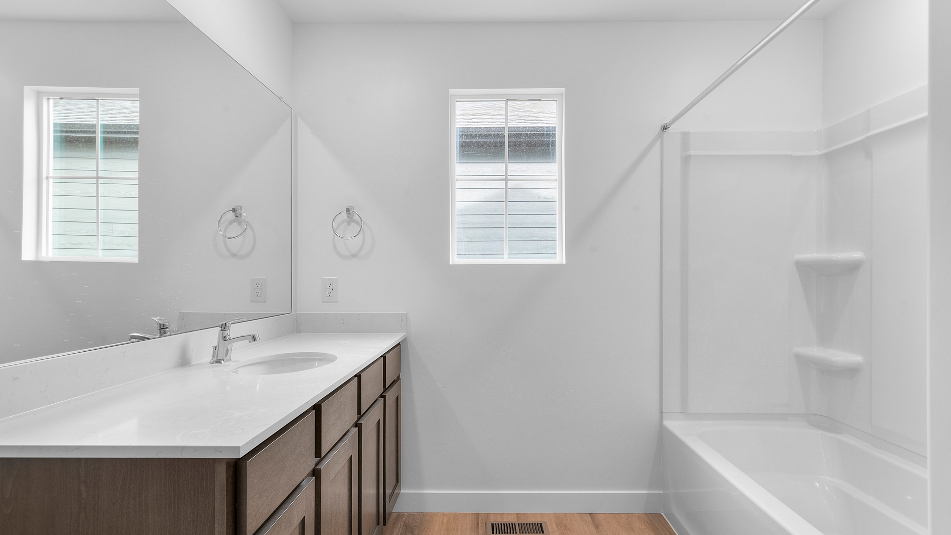 Primary bathroom with vanity and shower surround and window.