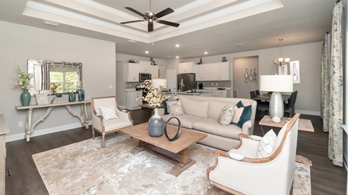A stylish kitchen with granite countertops and white cabinetry highlights the Katherine floorplan on the Mississippi Gulf Coast.