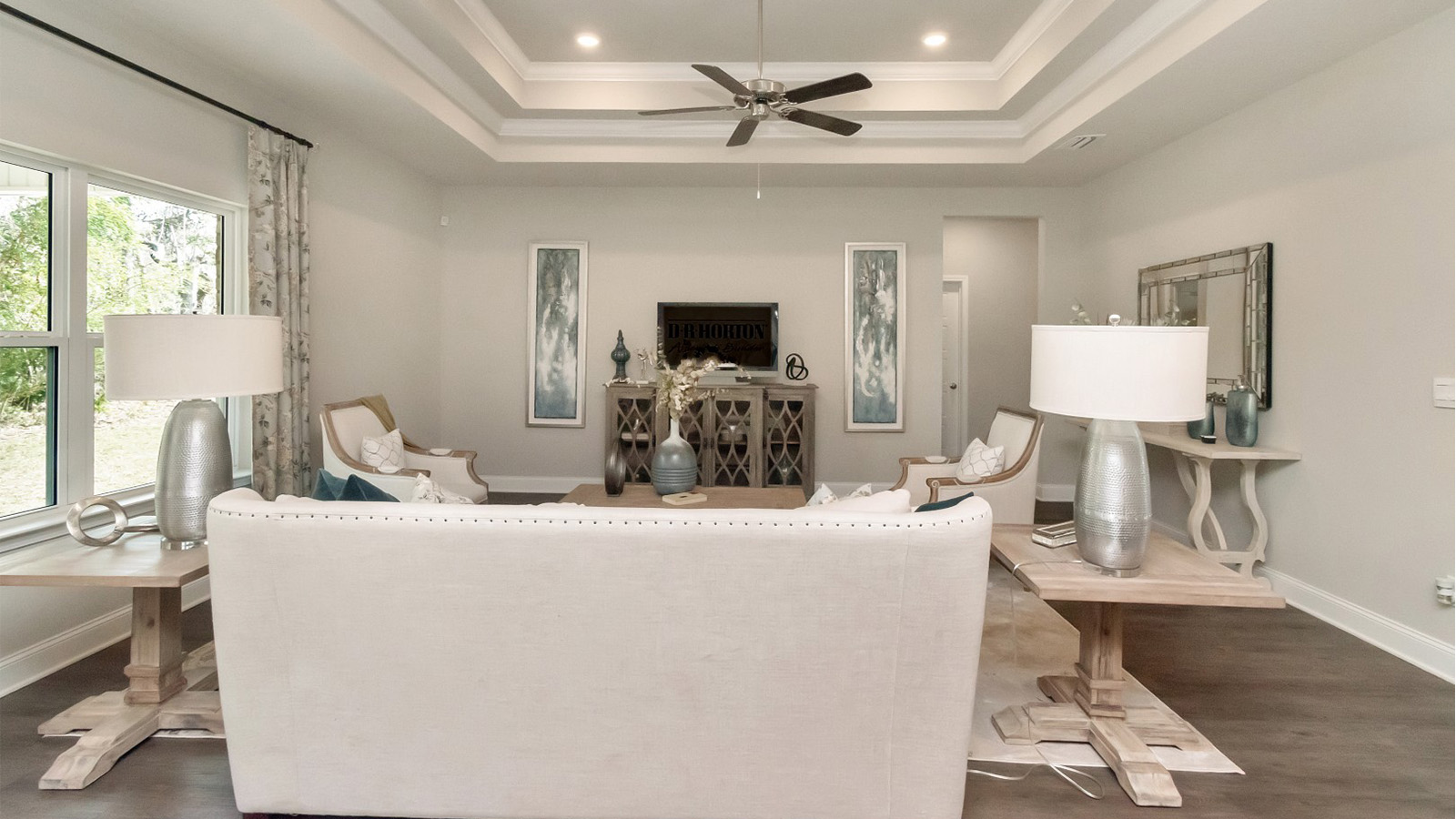Elegant tray ceilings elevate the design of this inviting living space in South Mississippi.