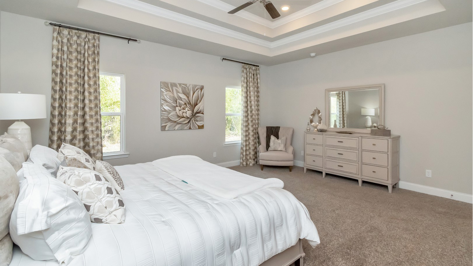 The owner’s suite features a tray ceiling and abundant natural light in this Ocean Springs home.