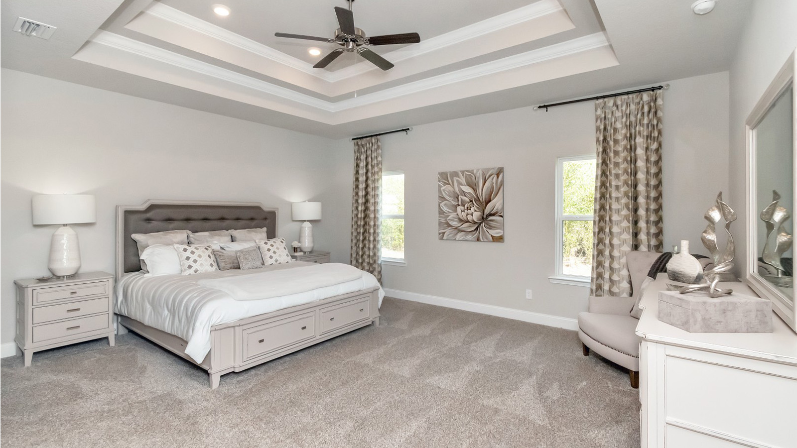 Enjoy a spacious primary bedroom with plush carpet and a tray ceiling in this South Mississippi home.