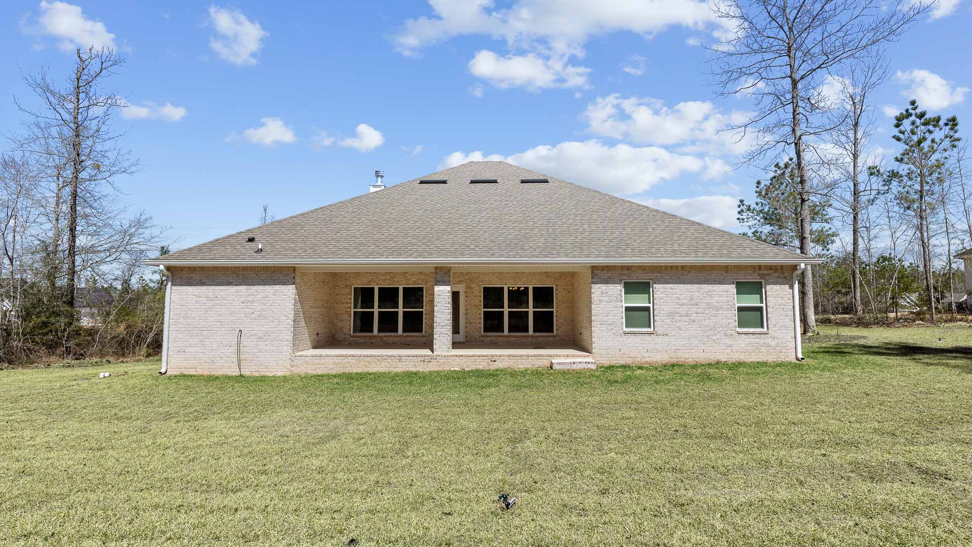 Rear view of a new home for sale with brick.