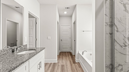 Sleek and spacious primary bathroom suite