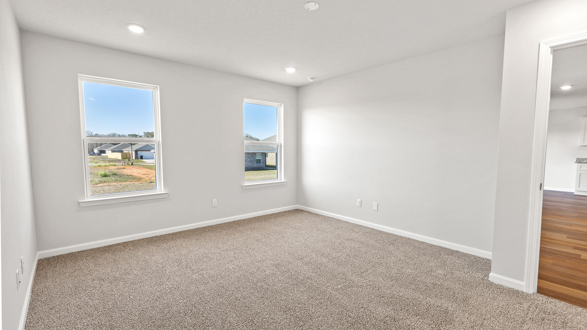 Bright primary suite with two windows and white trim in Biloxi.