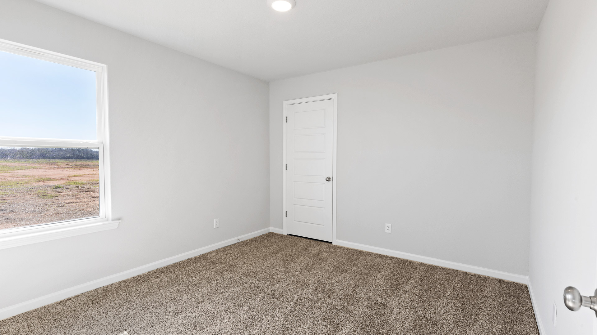Cozy guest bedroom with window and recessed lighting in Biloxi.