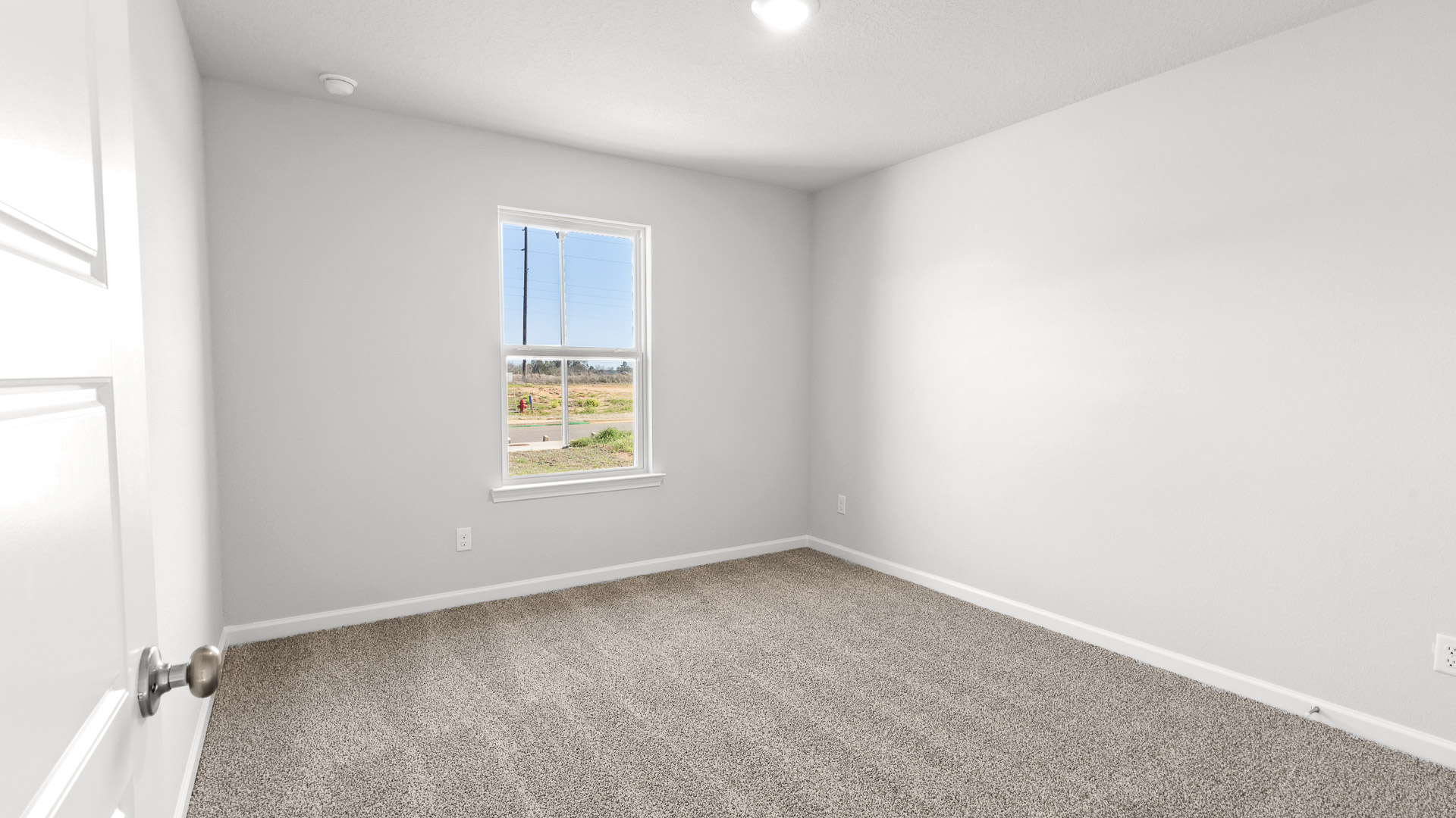 Inviting guest bedroom with plush carpet and white door.