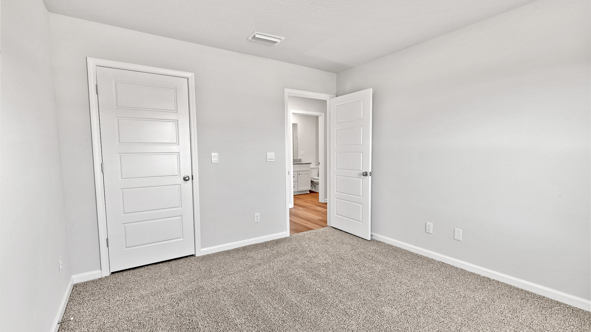 Guest bedroom with closet and neutral color palette.