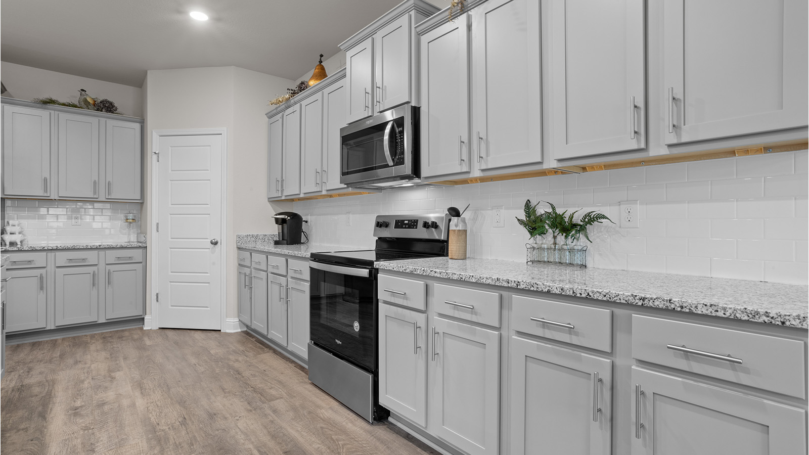Beautiful kitchen with gray cabinets and quartz countertops.